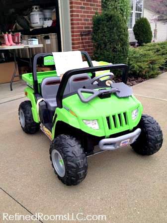 garage sale with high ticket item (kids jeep vehicle) featured in driveway.