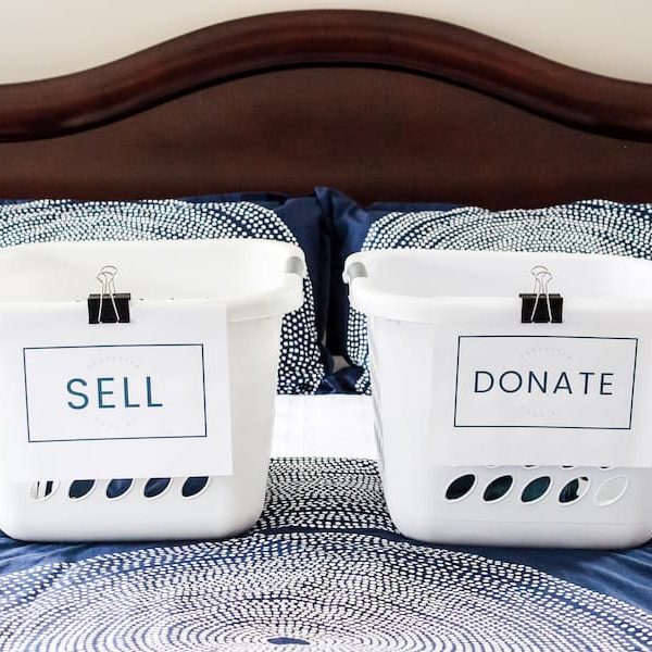 laundry baskets on a bed labeled "sell" and "donate".
