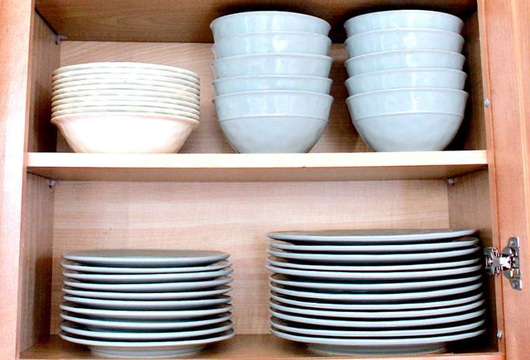 dishes and bowls organized in a kitchen cabinet.