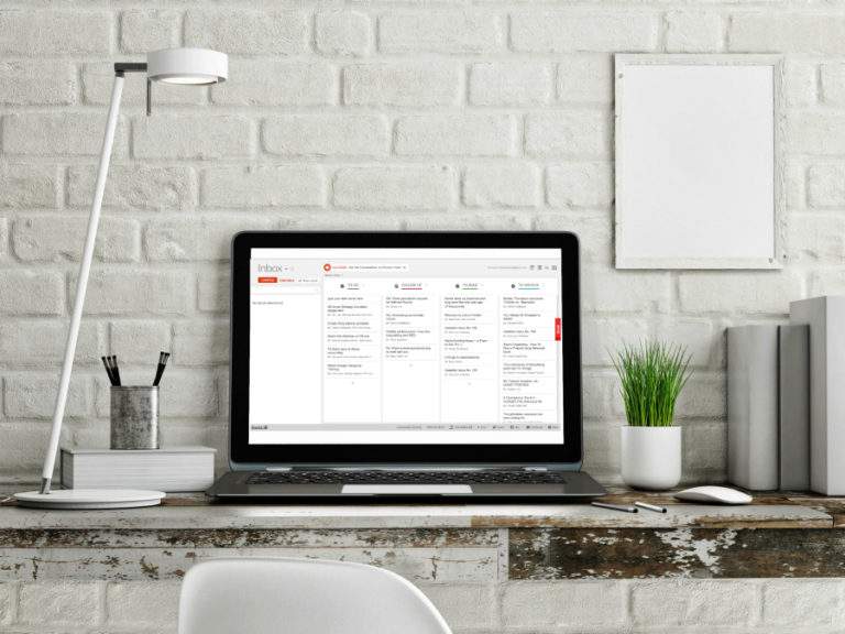 desktop with computer displaying an organized email inbox.