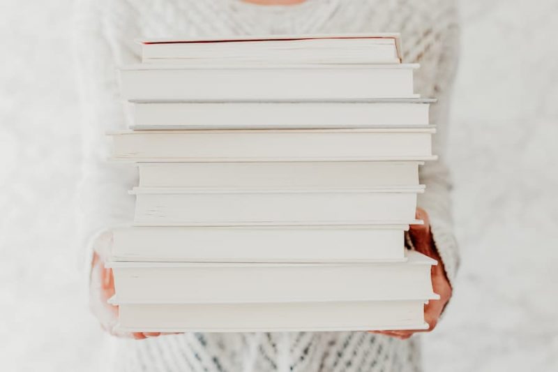 woman holding a stack of books