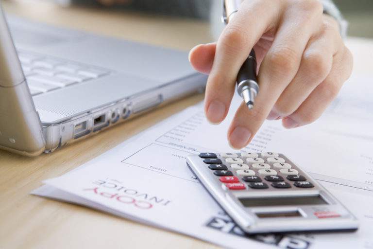 person using a calculator at a desk.
