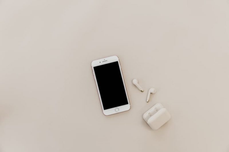 iphone and air pods on neutral background.