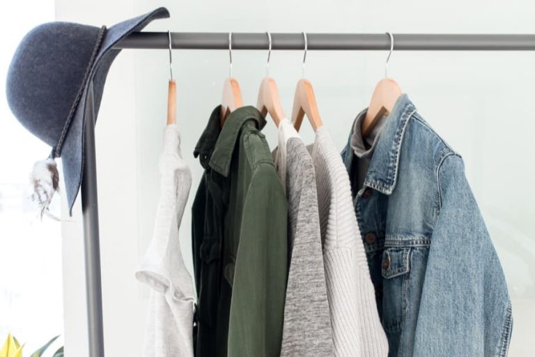 capsule wardrobe of 5 clothing items hanging on rod.