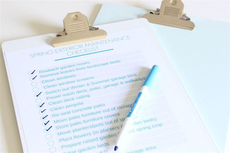 Spring exterior maintenance checklist attached to clipboard with pen.