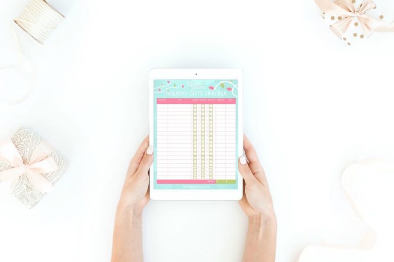 woman holding an ipad with printable gift tracker displayed.