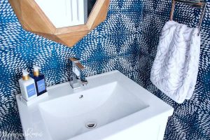 square white porcelain modern sink with soap and patterned hand towel.