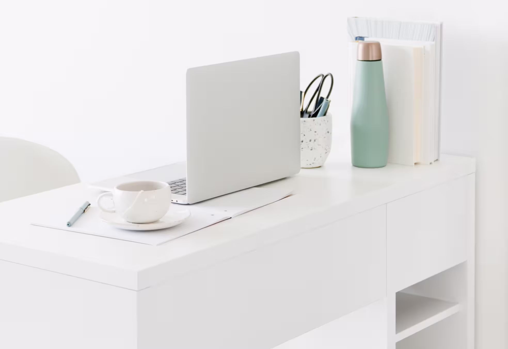 minimalist white workspace with laptop open.
