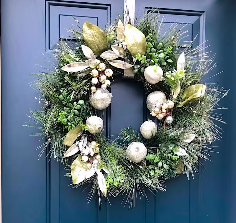 gold and green holiday wreath on a blue door.