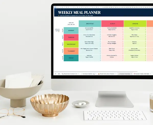 imac on desk displaying weekly meal planner spreadsheet on white desk with metal bowl on desk.